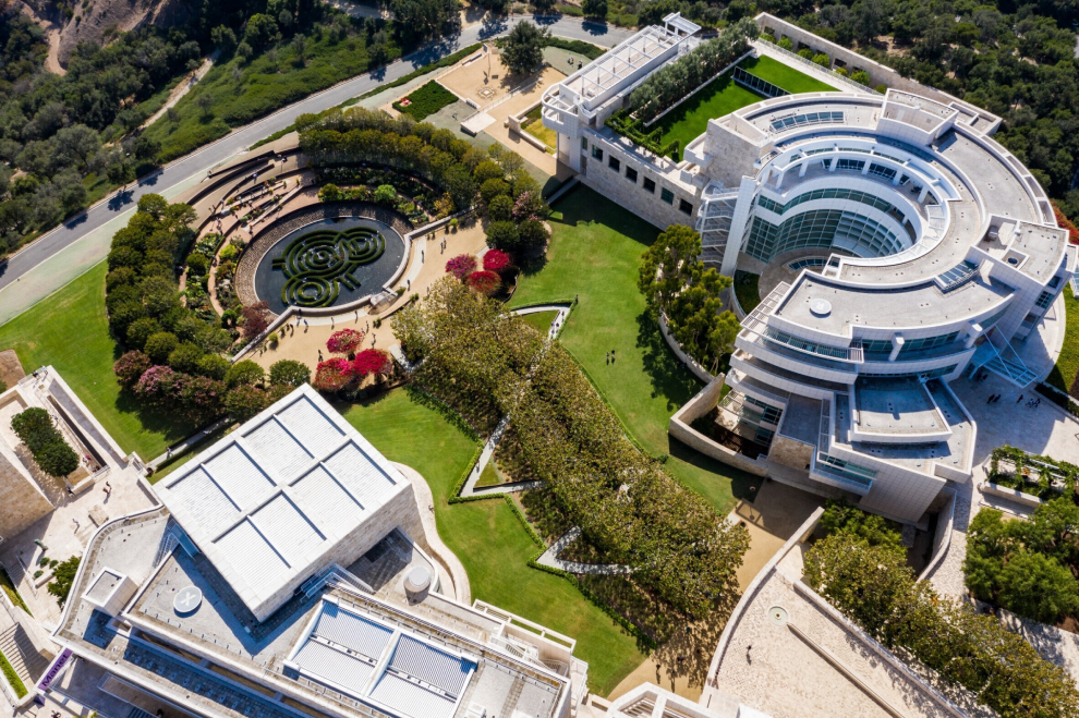 View of a wide expansive staircase leading up to the entrance of the Getty Center Museum, a white, two story building with a curvy shape like a piano